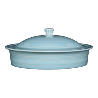 A light blue ceramic casserole dish with a matching domed lid and a small handle on top, set against a white background.