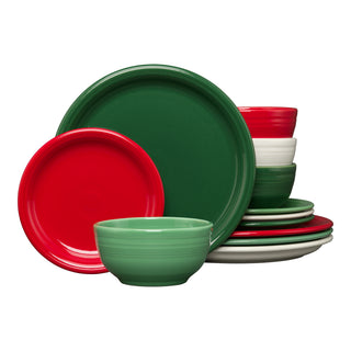A set of colorful dinnerware featuring plates and bowls in red, green, and white, arranged in stacked and standing positions against a white background.