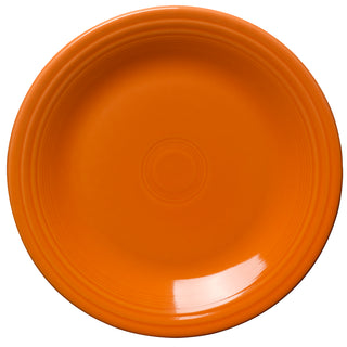 A round, orange ceramic plate with a glossy finish and concentric circle designs near the center and rim, shown against a white background.