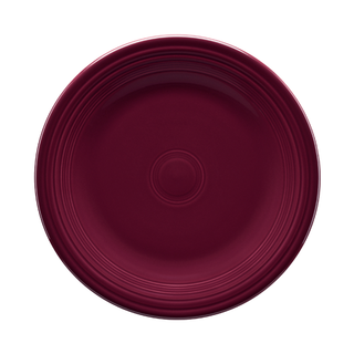 A round, deep burgundy ceramic plate with a glossy finish and concentric circle patterns along the rim, shown from a top-down view on a white background.