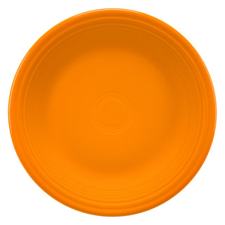 A plain, round orange plate with a slightly raised rim and concentric circle patterns near the edge, viewed from above against a white background.