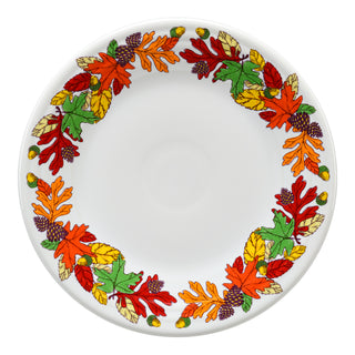 A white plate with a border of colorful autumn leaves and acorns in shades of red, orange, yellow, and green around the edge.