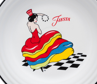 A plate featuring an illustration of a woman in a red dress with layered yellow, blue, and green ruffles, dancing on a black-and-white checkered floor, with the word Fiesta in red script.