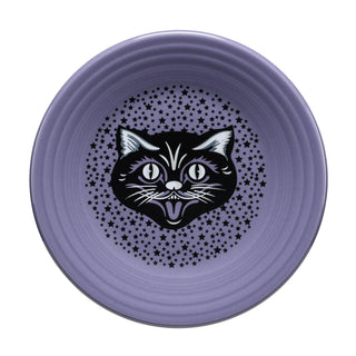 The Fiesta Black Cat Lavender Classic Rim 9 Inch Luncheon Plate, crafted in the USA from vitrified china, displays a black and white cartoon cat face at the center with a pattern of small black stars around it. It's also dishwasher safe for easy cleaning.