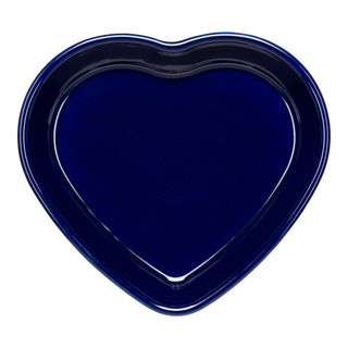 A dark blue, heart-shaped ceramic plate with a glossy finish and concentric circle designs in the center, shown against a white background.