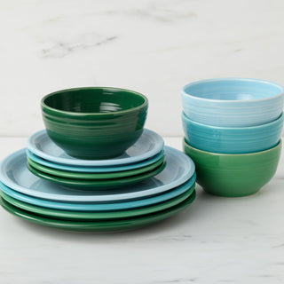 A stack of green and light blue plates with matching bowls from the Fiesta Mixed Aegean Bistro Coupe 12-Piece Dinnerware Set, Service for 4, arranged on white marble. This modern set is microwave and dishwasher safe.