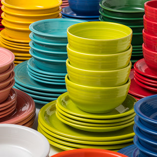 The Fiesta Retired Bistro Coupe 12-Piece Dinnerware Set, Service for 4, features colorful, lead-safe ceramic plates and bowls in yellow, green, blue, red, pink, orange, and white—made in the USA and arranged together on a flat surface.