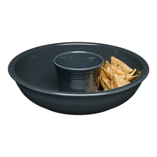 The Fiesta Retired Dip Bowl in dark gray china features tortilla chips in the outer section and an empty dip holder at the center, making it ideal for serving snacks with a signature pop of Fiesta style.
