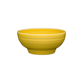The Fiesta Retired Small 5 1/8 Inch Footed Bowl (14 OZ) in sunflower features a bright yellow vitrified china with a glossy finish and subtle horizontal ridges, shown against a plain white background.