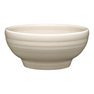 The Fiesta Retired Small 5 1/8 Inch Footed Bowl (14 OZ) in linen features a smooth finish with subtle horizontal ridges and is crafted from durable vitrified china, shown against a white background.