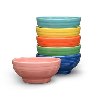 A stack of six Fiesta Retired Small 5 1/8 Inch Footed Bowls (14 OZ)—pink, turquoise, yellow, orange, green, and blue—arranged on a white background. Dishwasher safe and made in the USA.