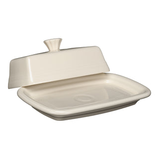 The Fiesta Linen Extra Large Covered Butter Dish (8 1/8" x 5 1/8"), an ivory-toned, dishwasher-safe ceramic piece with a matching lid slightly lifted to show its empty interior, is displayed against a white background.