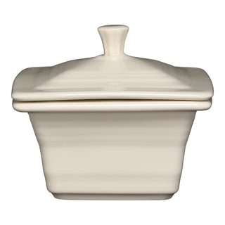 The Fiesta Retired Linen Covered Box (4 5/8" x 3 3/4") features a cream ceramic finish with a matching lid and rounded handle, ideal for kitchen storage. Made in the USA. Shown on a white background.