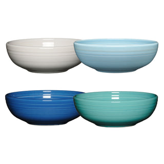 The Fiesta Mixed Coastal Blue Bistro Coupe 7 5/8-Inch 38OZ Medium Bowls set of 4 features lead-free ceramic bowls in white, light blue, dark blue, and teal, arranged in two rows against a white background.