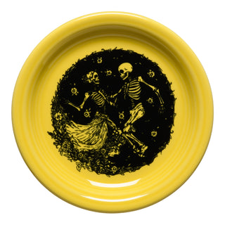 The Fiesta Retired Skeleton Duet Sunflower Bistro Coupe 6 1/4" Appetizer Plate showcases two skeletons dancing amid flowers and leaves in the center. Made in the USA and dishwasher safe.