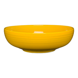 A Fiesta Retired Bistro Coupe 10 1/2 Inch Extra Large Bowl (96 OZ) in Daffodil, featuring a smooth, glossy finish and subtle horizontal ridges, made in the USA, is shown against a white background.