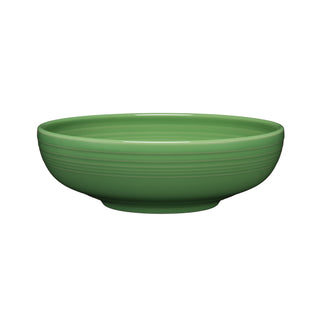 The Fiesta Retired Bistro Coupe 10 1/2 Inch Extra Large Bowl (96 OZ) in Meadow is a round, shallow green ceramic serving bowl with subtle horizontal grooves near the rim, made in the USA and shown on a white background.