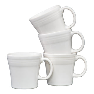 The Fiesta White 15 OZ Set of 4 Tapered Mugs, made in the USA, features a smooth ceramic design with subtle ridges near the rim. Dishwasher safe, these mugs are stacked with handles facing outward for a modern touch.