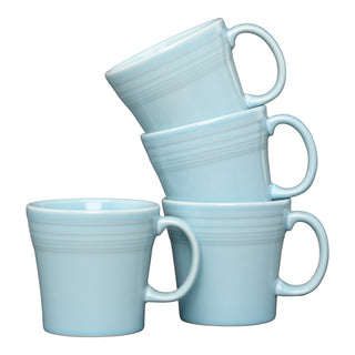 The Fiesta Sky 15 OZ Set of 4 Tapered Mugs features four light blue ceramic mugs stacked against a white background. Each microwave-safe mug is perfect for daily use.