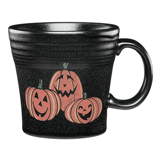 The Fiesta Trio of Happy Pumpkins Tapered Mug is a black ceramic 15 oz mug with three smiling orange jack-o’-lanterns on the front; dishwasher safe for easy cleaning.
