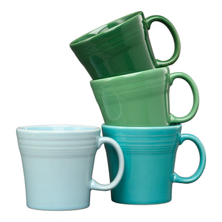 The Fiesta Mixed Aegean 15 OZ Set of 4 Tapered Mugs features ceramic mugs in shades of blue and green, each with a rounded design and a ridge near the rim. Made in the USA.