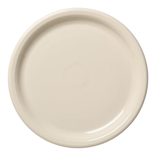 The Fiesta Bistro Coupe 10 1/2 Inch Dinner Plate in Linen is a plain, round, off-white china plate with a slightly raised edge and subtle concentric rings, crafted from lead-safe materials and shown on a white background.