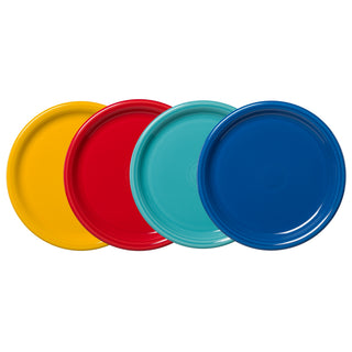 The Fiesta Mixed Vibrant Bistro Coupe 10½ Inch Dinner Plate Set of 4 features plain, glossy lead-safe china plates in yellow, red, light blue, and dark blue, arranged side by side with each one overlapping the next.