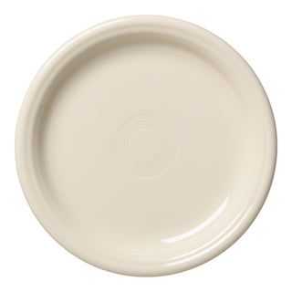 The Fiesta Bistro Coupe 7 1/4 Inch Salad Plate in Linen is a round, off-white ceramic plate with a subtle center pattern, shown from above on a white background. Microwave safe and ideal for daily use.