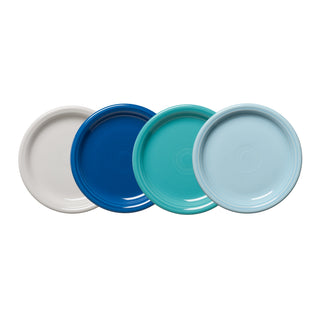 The Fiesta Mixed Coastal Blues Bistro Coupe 7 1/4 Inch Salad Plate Set of 4 features smooth, glossy plates in white, dark blue, teal, and light blue, each with a simple circular design.