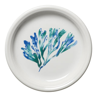 The Fiesta Retired Coastal Bistro Coupe 7 1/4 Inch Salad Plate is a white ceramic plate with blue and green abstract brushstroke accents at the center, evoking leaves or seaweed. It's dishwasher safe for easy cleaning.