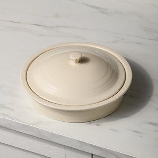 The Fiesta Small 10 Inch Round Covered Casserole (1.4 Quart) in beige features a smooth, glossy finish and matching lid, making it ideal for oven-safe meals or serving tortillas warm on your countertop.