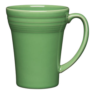 The Fiesta 18 OZ Bistro Latte Mug by Fiesta is a green vitrified ceramic mug made in the USA, featuring a smooth finish, curved handle, and horizontal ridges near the top. It's dishwasher safe and shown empty on a white background.