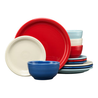 A vibrant stack of Fiesta's Mixed Americana Bistro Coupe 12-Piece Dinnerware Set with Sky Extra Large Bowl features red, blue, white, and light blue coupe pieces—all dishwasher safe for easy cleanup.