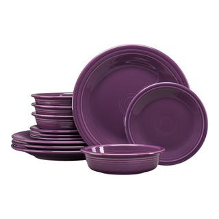 The Fiesta Retired Classic Rim 12-Piece Dinnerware Set in mulberry includes dinner plates, salad plates, and bowls for four. The stacked ceramic set is dishwasher safe and shown against a white background.