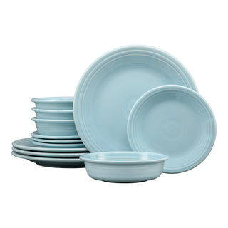 The Fiesta Classic Rim 12-Piece Dinnerware Set in sky, featuring dinner plates, salad plates, and bowls for 4, is displayed stacked and upright against a white background.
