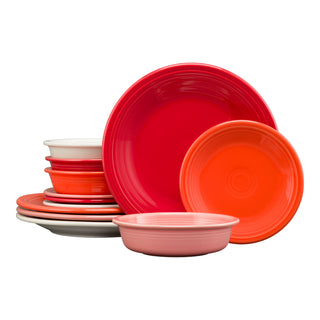 A vibrant Fiesta Mixed Sunset Horizon Classic Rim 12-Piece Dinnerware Set, Service for 4, features bowls and plates in red, orange, pink, white, and gray—stacked in groups against a white background.