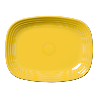 The Retired Fiesta 12 Inch Large Rectangular Platter by Fiesta, in a sunflower yellow ceramic with rounded corners and concentric raised lines, is made in the USA and shown on a white background.