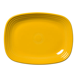 The Retired Fiesta 12 Inch Large Rectangular Platter by Fiesta in Daffodil is a bright yellow ceramic tray with rounded edges and concentric ridges near the rim, shown on a white background.