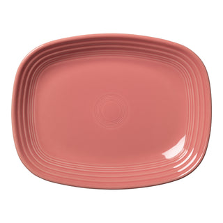 The Retired Fiesta 12 Inch Large Rectangular Platter by Fiesta in Peony is a pink ceramic tray with rounded corners and grooved edges, shown on a white background.