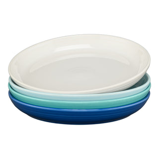The Fiesta Mixed Coastal Blues Coupe 10 3/8 Inch Dinner Bowl Set of 4 features white, light blue, teal, and dark blue bowls stacked for a serene display. Each holds 40 oz and adds coastal charm on a white background.