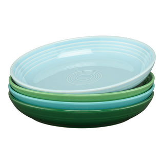The Fiesta Mixed Aegean Coupe set includes four 8½" luncheon bowls (26 OZ) in blue and green shades, inspired by Aegean colors. Each bowl features a subtle central spiral, stacked from light blue on top to dark green at the bottom.