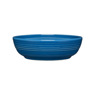The Fiesta Coupe 6 3/4 Inch Salad Bowl, 24 OZ, in lapis blue features a round, shallow shape with a smooth finish and horizontal ridges. Dishwasher safe for easy cleaning. Shown on a white background.