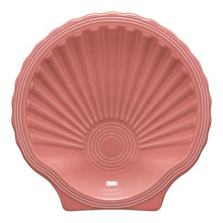 The Fiesta Retired Shell Shaped Plate 8 1/4 OZ in peony features seashell-like ridges and pink coloring. Made in the USA, it's ideal for collectors seeking unique, retired pieces.