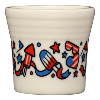 The Fiesta 4th of July 1½ oz ceramic shot glass features cream-colored vitrified china with red, white, and blue stars, rockets, and streamers. Durable, dishwasher safe, and made in the USA—perfect for patriotic celebrations.