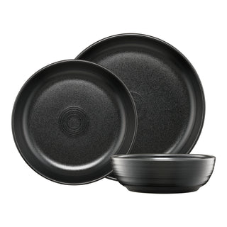 Fiesta Coupe Bowl 3-Piece Dinnerware Set Foundry: two black round plates of different sizes standing upright and a matching coupe bowl placed in front, all featuring a subtle textured finish—an elegant place setting made from lead-safe china.
