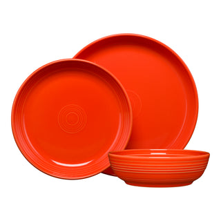 The Fiesta Coupe Bowl 3-Piece Place Setting includes two round plates and a matching bowl in bright orange, each accented with subtle concentric circle designs, arranged together on a white background for a bold presentation.