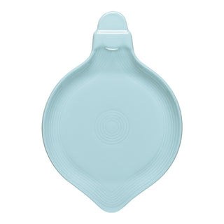 Light blue ceramic dish with a handle, rounded at the bottom and tapering at the top, featuring subtle concentric circle patterns in the center and a notch near the handle.