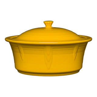 The Fiesta Large 10 Inch Round Covered Casserole (2.8 Quart) in daffodil features a matching lid and two side handles. This oven-safe ceramic dish is made in the USA and displayed against a white background.
