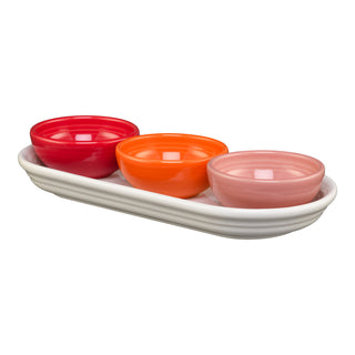 The Fiesta Sunset Horizon Mixed Colors 4-Piece Condiment Set features three vibrant mini bowls in red, orange, and pink, arranged on a sleek white tray against a crisp white background.