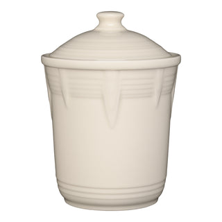 The Fiesta Retired Linen 2 Quart Medium Chevron Canister is a cream ceramic jar with a matching lid and subtle raised chevron lines, providing an elegant, airtight storage solution for your kitchen.